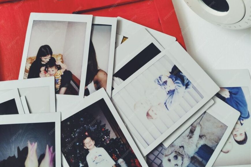 A stack of polaroid photos on top of a red box.