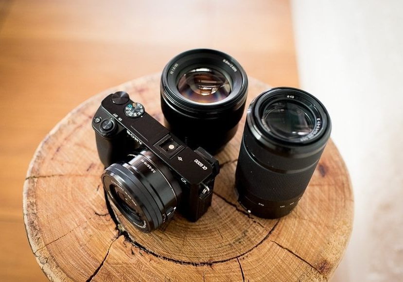 sony a6000 surrounded by lenses on a wooden post sony a6000 surrounded by lenses on a wooden post